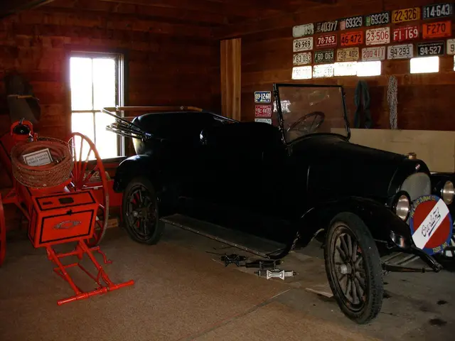 Vintage car and antique fire cart in a museum barn